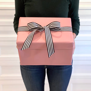 Small shoebox sized pink collapsible gift box with black and white grosgrain ribbon attached, great zero waste solution for sustainable and eco-friendly gift boxes